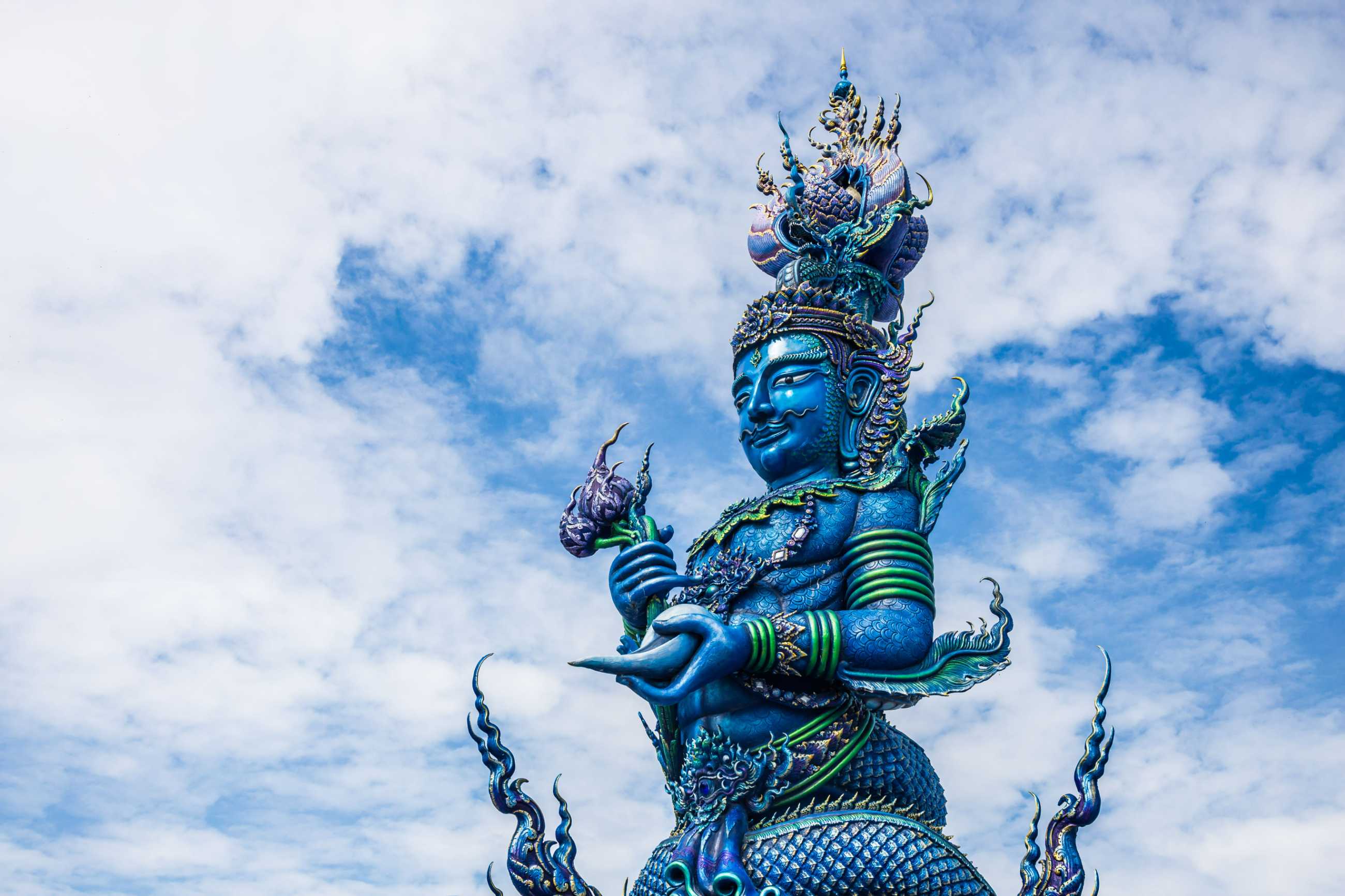 pole-carve-art-fairy-tale-wat-rong-sua-ten-temple-with-blue-sky-background_jadtrip.com.jpg